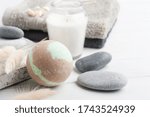 Bath bombs in spa composition with dry flowers, lit aroma candles and towels. Aromatherapy arrangement, zen still life