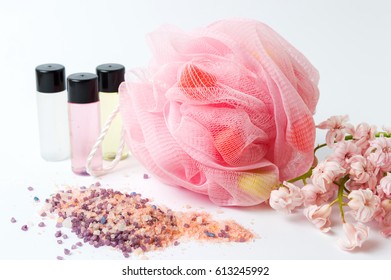Bath sponge and salt with pink flowers and essential oils