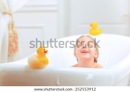 Bath time is fun. Selective focus image of a cute little girl taking a bath and playing with rubber ducks while sitting in a luxurious bathtub 