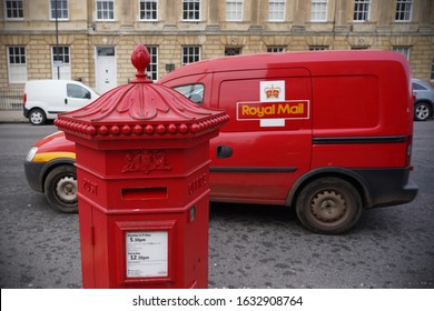 Bath, UK - November 30, 2019: A Traditional British Red Post Box And Royal Mail Post Delivery Van Are Seen On A City Centre Street.