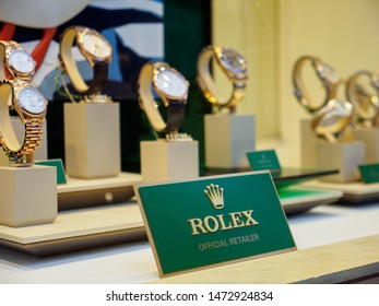 BATH, UNITED KINGDOM - MARCH 5, 2019: Wide Close-up Of A Rolex Plaque On Display Next To Multiple Gold Datejust, Cellini, And Other Watches At A Boutique. Luxury Swiss Timepiece Industry.