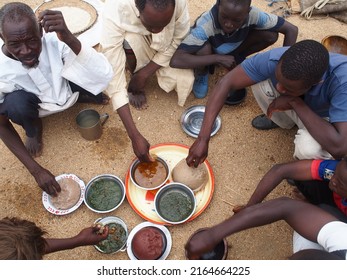 Batha, Chad, Africa, April 12 2017, A Group Of Men Share A Meal On The Ground Without A Table In The Sahel Desert