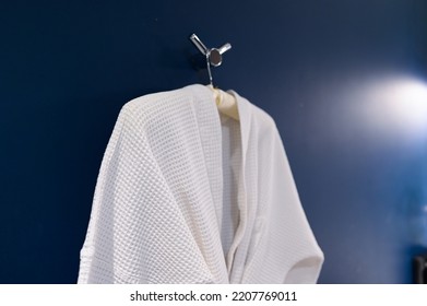 Bathrobe Hanging On Dark Blue Wall