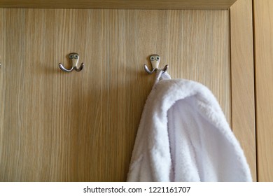 Bathrobe hanging on the hook. Classic bathrobe hanging on wooden abstract wall hook mounted against wooden wall - Powered by Shutterstock