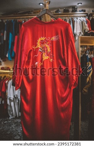 Bathrobe hanging in a store. 
Vintage Chinese red bathrobe with a dragon design in the middle.