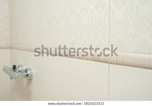 Bathroom ceramic tiles on the wall, beige color,\
pattern, dividing\
strip.