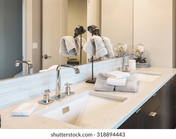 Bathroom Detail In New Luxury Home: Vanity With Cabinet. Dual Sinks And Counter Decorated With Towels