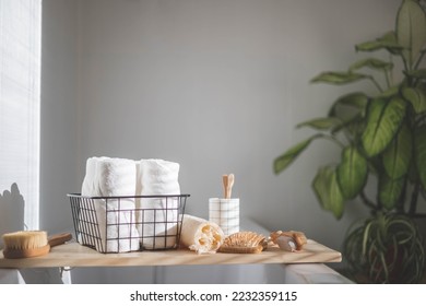 Bathroom domestic spa procedure body care tools arrangement minimal ecology space organization. Bath interior eco friendly materials rolled towels soap hairbrush toothbrush washcloth at sunlight