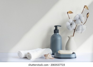 Bathroom interior in beige pastel tone. White shelf in bathroom with towels, soap, shampoo bottle, houseplant. Mockup with space for text. Minimal composition. - Powered by Shutterstock