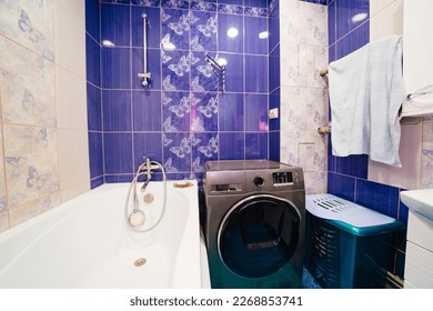 bathroom interior with blue ceramic tiles on the walls. outdated, non-modern repairs in the apartment.