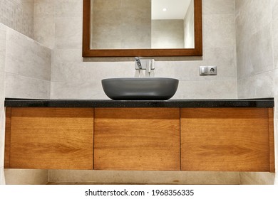 Bathroom Interior With Brown Wood Bedside Table With Gray Washbasin, Mirror On Gray Marble Tiles Background