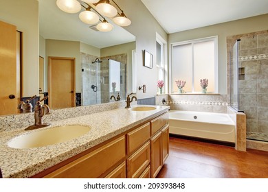 Bathroom Interior With Granite Top Cabinet, White Bath Tub And Glass Door Shower