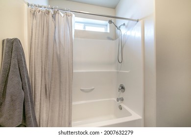 Bathroom interior with tub shower combo and window