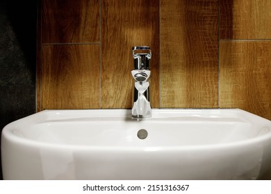 Bathroom Interior With White Sink And Faucet. Water Faucet And White Sink And Ceramic Tile With Imitation Brown Wood.