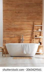 Bathroom Interior With White Tub And Decor Near Wooden Wall