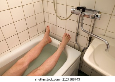 Bathroom, Male Legs In Bathtub Man Taking Bath White Tile Walls Sink And Bathroom Faucet Middle Class Bathroom Minimal Interior