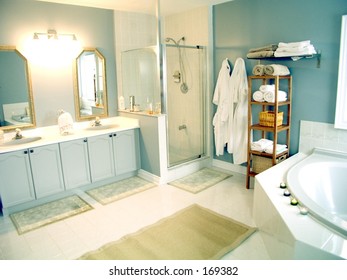 Bathroom with mirrors,white porcelain fixtures,   pastel walls, shower stall and whirlpool bathtub.