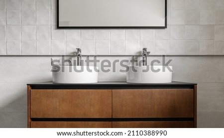 Bathroom modern vanity unit with two round ceramic sinks,  chrome faucets and mirror with black frame, white tales and wooden cabinet. Contemporary bathroom interior in minimalist Scandinavian style