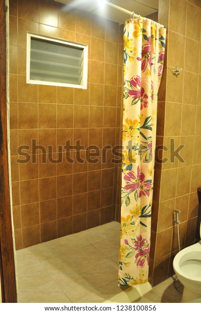 Bathroom in the\
resort Beautifully decorated in brown tone.Have a vent And plastic\
curtains divide the shower\
zone.