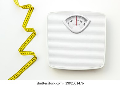 bathroom scales and measuring tape for weight loss concept on white background top view