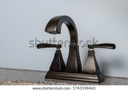 Bathroom sink faucet with water dripping. Concept of DIY home repair, plumbing maintenance, clean water, water conservation