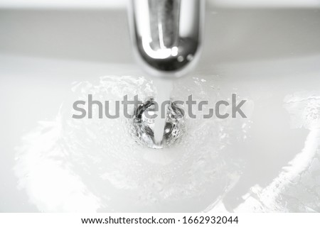 bathroom sink or hand basin with running water - close-up with shallow depth of field and motion blur