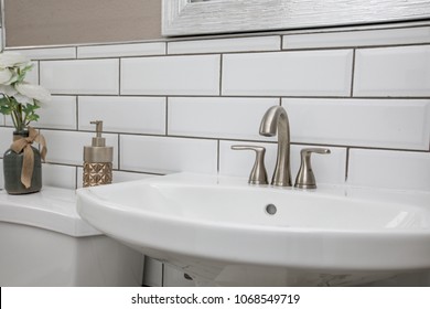 Bathroom sink shot close up with a modern design white subway tile backsplash