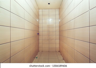 Bathroom with tiled walls before installing shower and sink, is in the apartment that is under construction, remodeling, renovation, overhaul, extension, restoration and reconstruction. Concept of