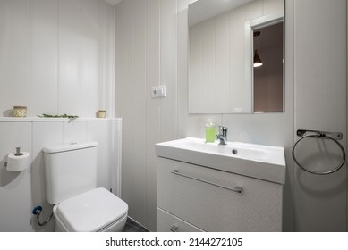 Bathroom with white porcelain sink on white wood cabinet, square frameless mirror and chrome accents - Shutterstock ID 2144272105