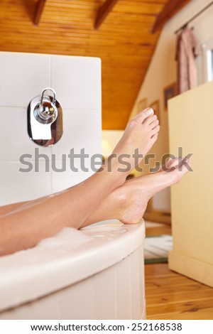 Bathtime. Girl's feet sticking out from bath tub.