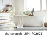 Bathtub, chest of drawers with sink and shelving unit in interior of bathroom