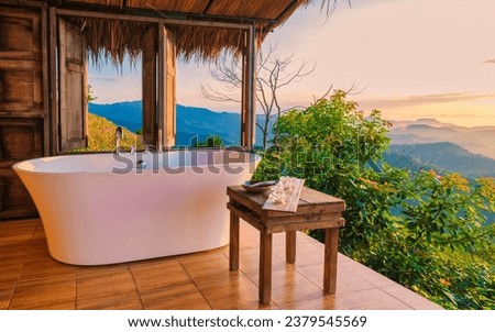 bathtub looking out over the mountains of Chiang Rai Northern Thailand during vacation. Outdoor bathroom, bathtub during sunset