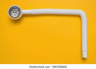 Bathtub Overflow Neck With A Plastic Hose On The Yellow Flat Lay Background.