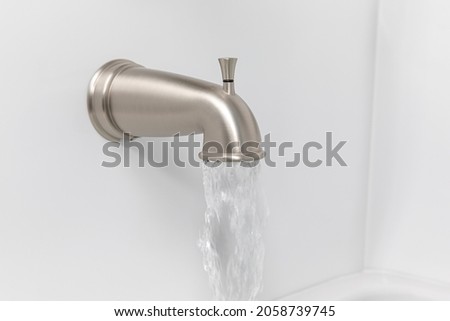Bathtub spout flowing water. Plumbing repair, bathroom remodel and renovation concept