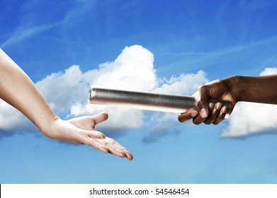 Baton Handoff With White Clouds And Blue Sky In Background. Horizontal Shot.