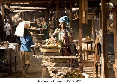 BATOUFAM - CAMEROON / 14.01.2015: African woman is selling grilled bananas in the  local market on the road to Batoufam
