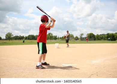 Batter at a Baseball practice, unrecognizable blurred people in background