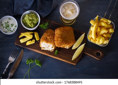 Battered Fish With French Fries, Mushy Peas And Sauce. Fish And Chips, Glass Of Beer. Overhead Horizontal Image