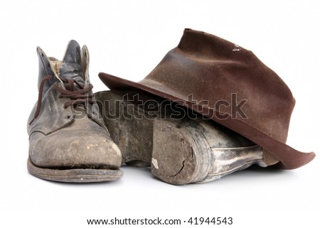 Battered old workboots and felt hat, isolated on white.  Well used from the 1940's until recently.