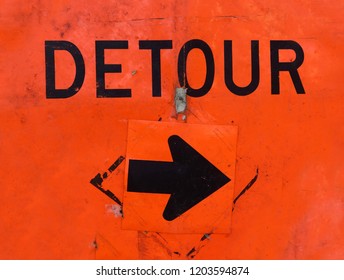 Battered Orange DETOUR Sign With Arrow.