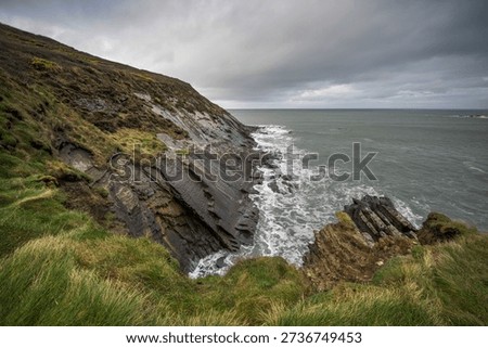 Battered rugged cliff face at Crackington Haven beach Cornwall at high tide