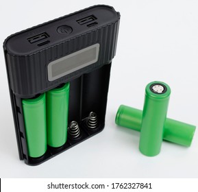 Battery bank using 18650 lithium-ion cells. Two cells are connected and two cells are outside the battery bank. Two USB outputs.