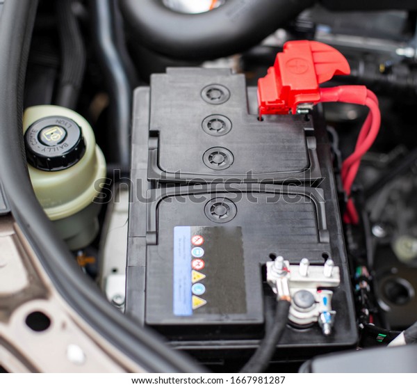the battery in the car in the engine\
compartment, background, accumulator\
battery
