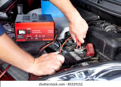 Battery charger and car in auto repair shop.