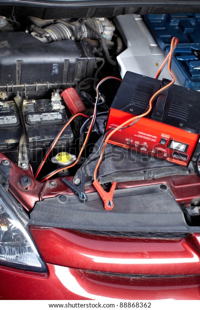 Battery charger and\
car in auto repair\
shop.