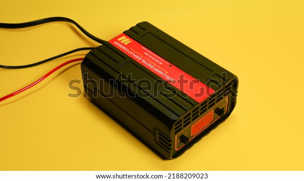 Battery charger for lead acid or\
accumulator battery types on yellow background\
isolated
