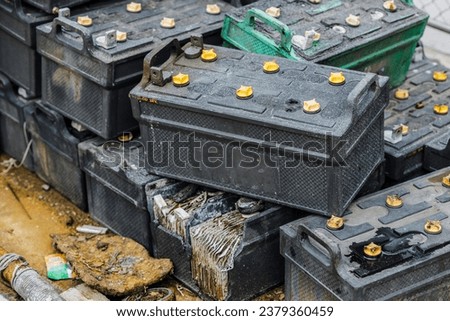 Battery waste. Pile of old used EV car batteries toxic waste chemicals lead leak impact nature no recycled.