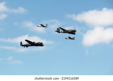 Battle of britain memorial flight including a spitfire, hurricane, Dekota and bomber flying in formation over an airshow