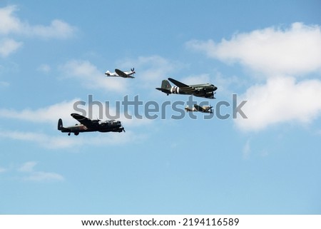 Battle of britain memorial flight including a spitfire, hurricane, Dekota and bomber flying in formation over an airshow