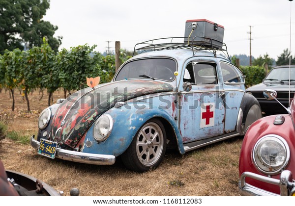 Battle Ground, WA / USA - August 25 2018:\
Rusted blue Volkswagen car with red\
cross